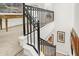 Carpeted staircase with black metal railing and white trim, complemented by artwork on the walls at 226 N Cleveland St # 226E, Indianapolis, IN 46204