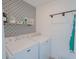 Well-lit laundry room with washer, dryer, patterned accent wall, and storage shelf at 2349 Dixon Creek Dr, Whitestown, IN 46075