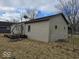 Exterior side view of a single-story home with weathered siding and a small deck at 2420 N Macedonia Ave, Muncie, IN 47303