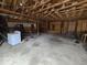 Unfinished garage interior featuring exposed beams, concrete floor, and a washing machine at 2420 N Macedonia Ave, Muncie, IN 47303