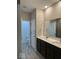 Bathroom with dual sinks, gray wood-style tile floors, and lots of light at 2536 Lanai Ln, Greenwood, IN 46143