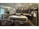 The kitchen has dark wood cabinetry, stainless steel appliances, and an island with seating at 2536 Lanai Ln, Greenwood, IN 46143