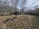 Wide view of the unkempt backyard with sheds, debris, and overgrown vegetation at 312 N Grafton Ave, Muncie, IN 47303