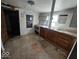 Kitchen with vintage appliances and wooden cabinets amidst peeling floors at 312 N Grafton Ave, Muncie, IN 47303