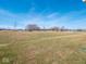 Expansive backyard featuring a large grassy area and mature trees under a bright blue sky, perfect for recreation at 3252 Jasper Ln, Brownsburg, IN 46112