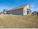 Side view of the backyard featuring green grass, a covered patio, and the back of the home at 3252 Jasper Ln, Brownsburg, IN 46112