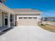 A two-car garage with an inviting front porch featuring stylish decor in front of a well kept lawn at 3252 Jasper Ln, Brownsburg, IN 46112