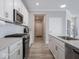 Bright kitchen showcasing stainless steel appliances, countertops, white cabinetry, and wood flooring at 3252 Jasper Ln, Brownsburg, IN 46112