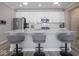 Kitchen island with gray stools, stainless steel appliances, and white cabinets, creating a modern aesthetic at 3252 Jasper Ln, Brownsburg, IN 46112