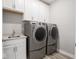 Modern laundry room equipped with new front loading machines, sink and cabinets at 3252 Jasper Ln, Brownsburg, IN 46112