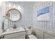 Chic powder room with patterned wallpaper, a round mirror, and a white vanity at 3342 Challenger Dr, Plainfield, IN 46168