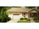Inviting home with an attached garage, red shutters, and lovely landscaping with green bushes and trees at 338 N Darlington St, Jamestown, IN 46147