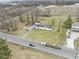 Aerial photograph of a home with a long driveway and a large green lawn, adjacent to a field, offering privacy at 4251 W 176Th St, Sheridan, IN 46069