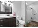 Bathroom featuring dark wood vanity, toilet, and tiled shower with curtain at 4407 Barnor Dr, Indianapolis, IN 46226