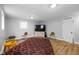 The spacious bedroom has natural light from two windows, vinyl wood flooring, neutral colors and simple furniture at 4407 Barnor Dr, Indianapolis, IN 46226