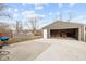 View of the gray detached garage with an open bay door and a concrete pad with some yard area at 4407 Barnor Dr, Indianapolis, IN 46226