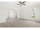 Spacious bedroom with a ceiling fan, neutral carpet, and natural light from the window at 524 S State St, Greenfield, IN 46140