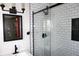 This bathroom features a glass shower with subway tile and black trim with updated vanity at 6041 Dewey Ave, Indianapolis, IN 46219