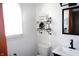 Bright bathroom features a modern black faucet, toilet, shelving unit and decorative sign at 6041 Dewey Ave, Indianapolis, IN 46219