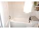 Bathroom with white tiling, a deep bathtub, and sleek fixtures at 6041 Dewey Ave, Indianapolis, IN 46219