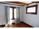 Bedroom with wood floors and white walls featuring a window with curtains and a vintage window at 6041 Dewey Ave, Indianapolis, IN 46219