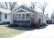 Charming home featuring a brick foundation, enclosed sunroom, and a detached garage at 6041 Dewey Ave, Indianapolis, IN 46219