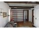 Spacious living room features exposed beams, built-in bookcase, hardwood floors, and natural light at 6041 Dewey Ave, Indianapolis, IN 46219