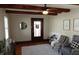 Cozy living room featuring hardwood floors, ceiling fan, and front door access at 6041 Dewey Ave, Indianapolis, IN 46219