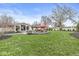 Expansive backyard featuring a patio, fire pit, manicured lawn, and mature trees at 671 Spring Hills Dr, Zionsville, IN 46077