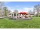 Expansive backyard featuring a stone patio with seating, a fire pit, manicured lawn and a charming, well-maintained home at 671 Spring Hills Dr, Zionsville, IN 46077