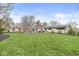 Sprawling backyard with a stone patio, outdoor seating area, and charming exterior with a well-manicured lawn at 671 Spring Hills Dr, Zionsville, IN 46077