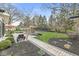 Backyard featuring a stone patio, built-in fire pit, and mature landscaping at 671 Spring Hills Dr, Zionsville, IN 46077