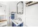 Stylish powder room with blue vanity, modern fixtures, and decorative shelving at 671 Spring Hills Dr, Zionsville, IN 46077