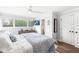 Tranquil bedroom with hardwood floors, a large window, and a view of the ensuite bathroom at 671 Spring Hills Dr, Zionsville, IN 46077