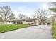 Charming single-story home with stone and white siding, a long driveway, and a three car garage at 671 Spring Hills Dr, Zionsville, IN 46077