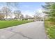 Charming home with well-maintained lawn, mature trees, a long driveway leading to a stone exterior and multiple garages at 671 Spring Hills Dr, Zionsville, IN 46077
