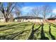 View of the backyard with a lush lawn and mature trees providing ample shade at 7133 Mc Lain Dr, Indianapolis, IN 46217