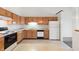 Spacious kitchen with natural wood cabinetry, modern appliances, and tile floors, creating a warm and inviting space at 7164 Long Shore Cir, Indianapolis, IN 46217