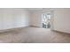 Bright, carpeted living room featuring neutral tones and a sliding door leading to the outdoor living area at 7164 Long Shore Cir, Indianapolis, IN 46217