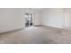 View of the carpeted living room featuring neutral tones and a sliding door leading to the outdoor living area at 7164 Long Shore Cir, Indianapolis, IN 46217