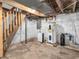 Unfinished basement featuring a wooden staircase, water heater and painted brick at 7540 S Mooresville Rd, Indianapolis, IN 46221
