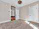 Bright bedroom featuring neutral walls, carpeted floors, and a modern ceiling light fixture at 7540 S Mooresville Rd, Indianapolis, IN 46221
