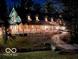 Charming two-story home with a covered porch illuminated at night, decorated with festive holiday lighting at 7540 S Mooresville Rd, Indianapolis, IN 46221