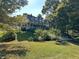 Charming two-story home with a covered porch surrounded by lush green trees in the neighborhood at 7540 S Mooresville Rd, Indianapolis, IN 46221