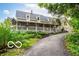 Charming two-story home with a covered porch, decorated with patriotic bunting and lush landscaping at 7540 S Mooresville Rd, Indianapolis, IN 46221