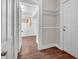 Hallway with wooden floors, white walls and shelving looking into another room at 7540 S Mooresville Rd, Indianapolis, IN 46221