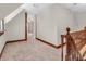 Upstairs hallway with neutral paint, carpet, and wood trim, offering access to other rooms at 7540 S Mooresville Rd, Indianapolis, IN 46221