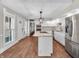 Bright kitchen with white cabinets, an island with a cooktop, and stainless steel appliances at 7540 S Mooresville Rd, Indianapolis, IN 46221