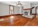 Bright living room with hardwood floors, stone fireplace, and a large window with floral curtains at 7540 S Mooresville Rd, Indianapolis, IN 46221