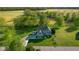 Aerial view of home with lush surrounding trees, a long driveway, basketball hoop, and manicured lawn at 7845 W Hillside Dr, Columbus, IN 47201